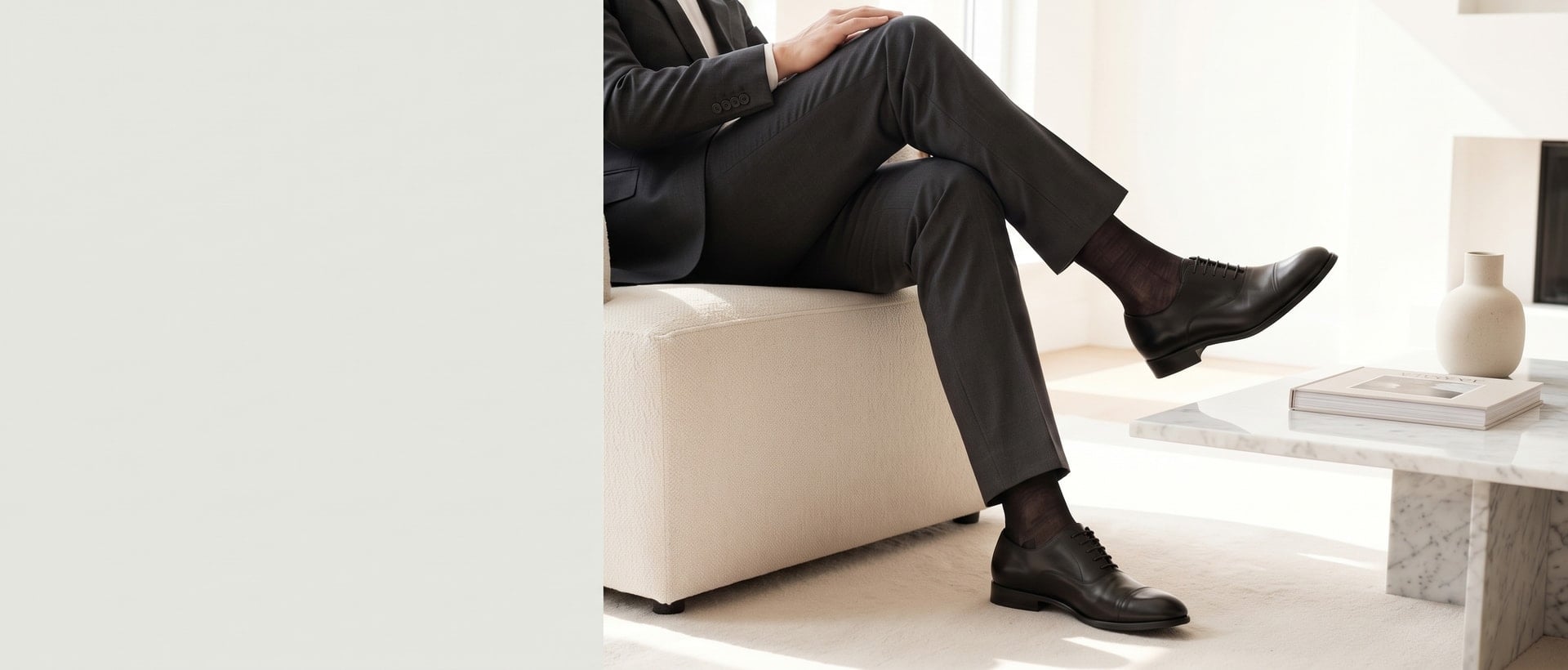 Hombre elegante con traje oscuro sentado con calcetines finos y zapatos Oxford negros