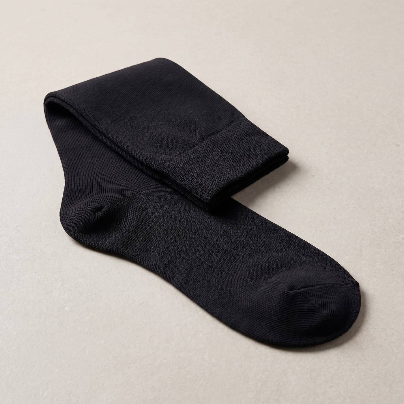 Detailansicht einer langen schwarzen Socke mit RippenbĂŒndchen, verstĂ€rkter Ferse und Zehe