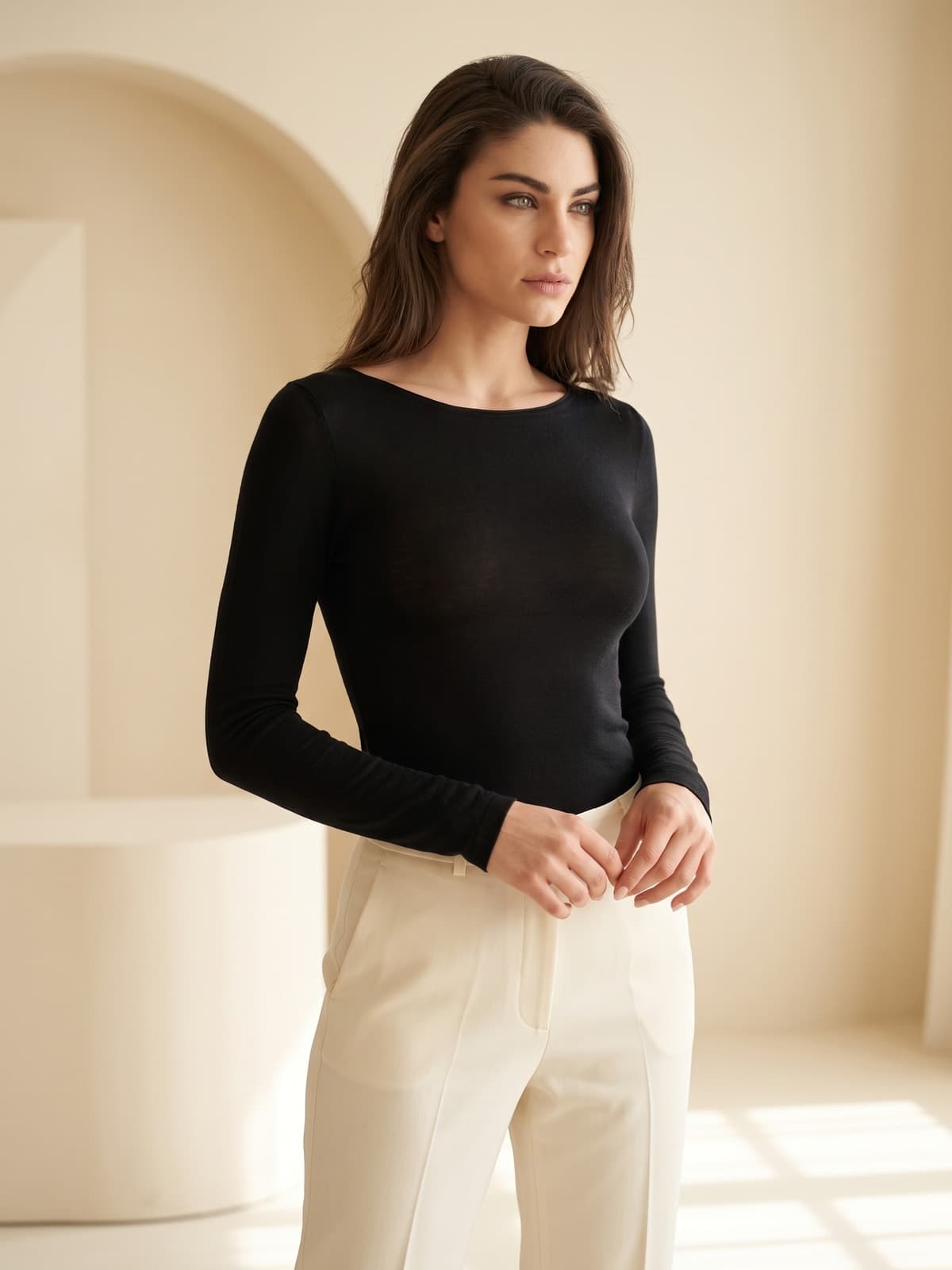 Mujer con camiseta interior negra de manga larga y escote barco, pantalón crema