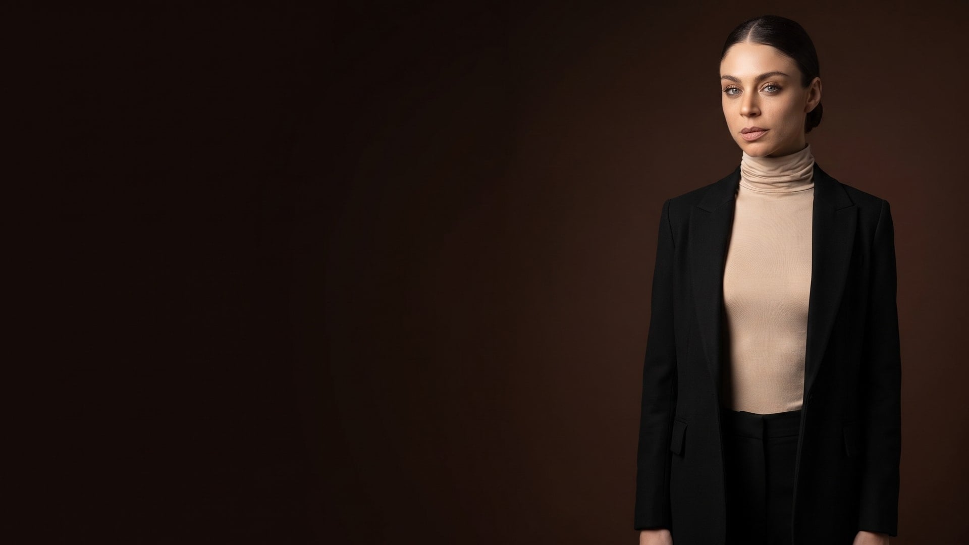 Donna con maglia dolcevita beige sotto un blazer nero